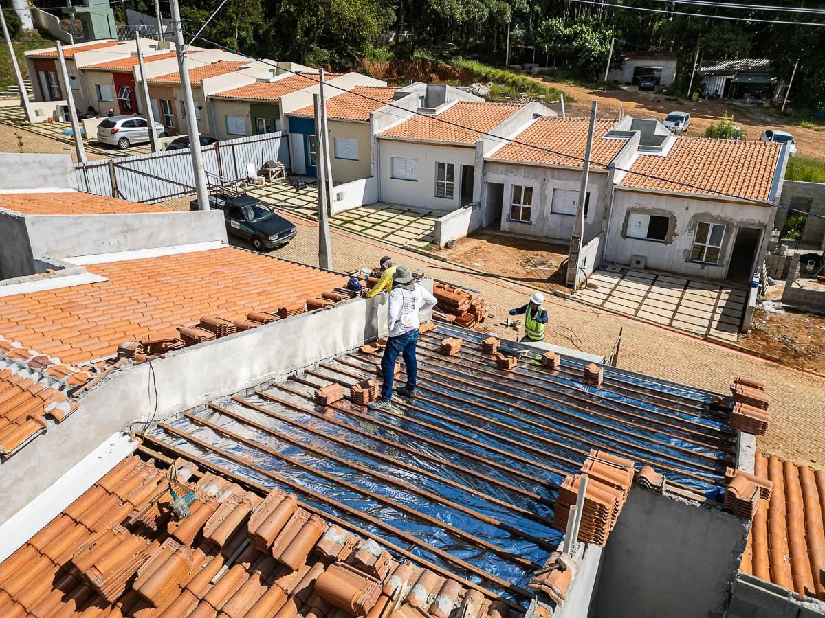 Casas em obra no Max Club Jarinu vistas por drone, com operários montando o telhado