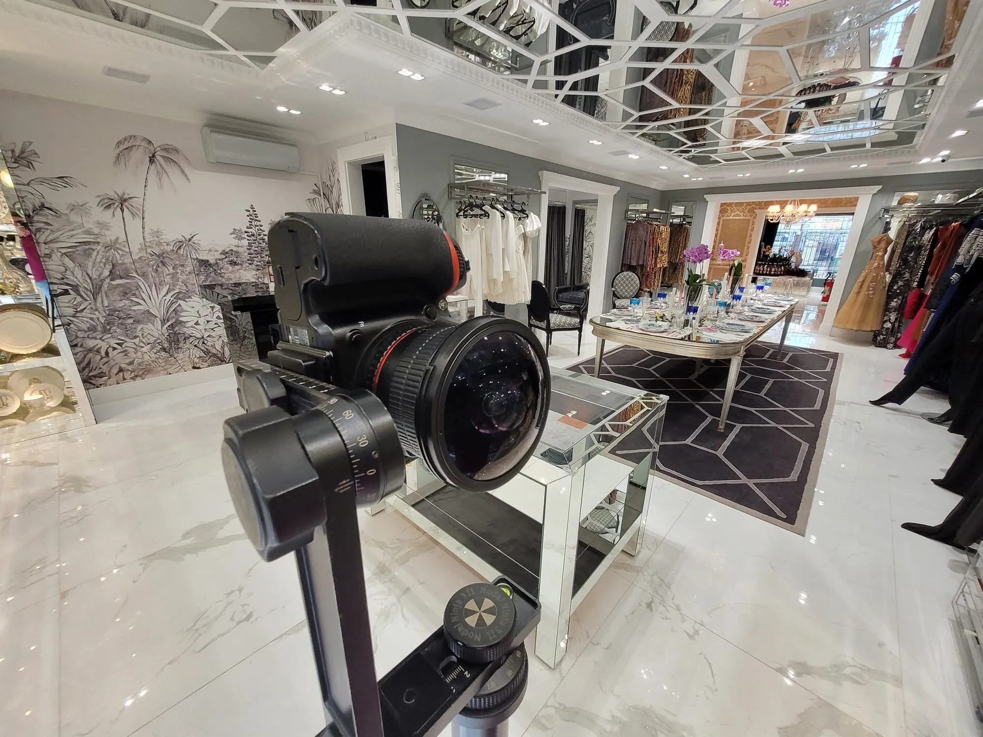 Câmera Nikon com lente olho de peixe na cabeça panorâmica Nodal Ninja 3, no salão do Atelier Sandro Barros, com teto de espelhos em treliça, piso de mármore polido, mesa posta e araras de vestidos ao fundo