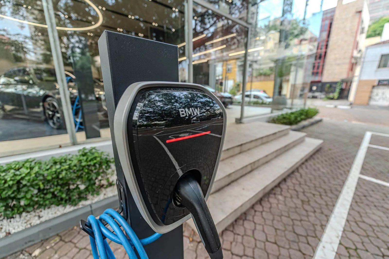 Carregador BMW para carros elétricos na calçada em frente à concessionária