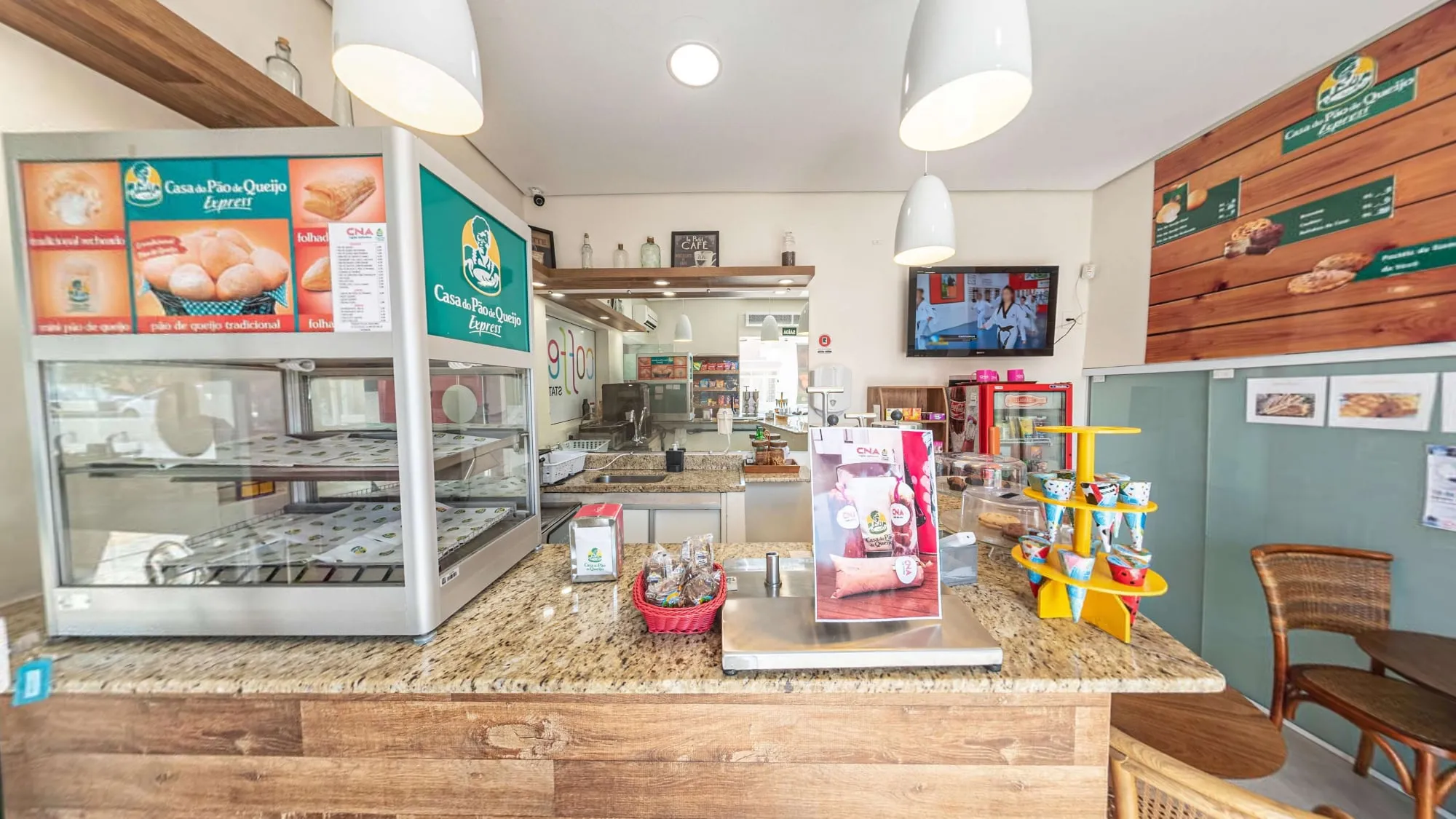 Café do CNA Itapetininga, com vitrine de salgados, balcão de granito e painel de madeira com o cardápio