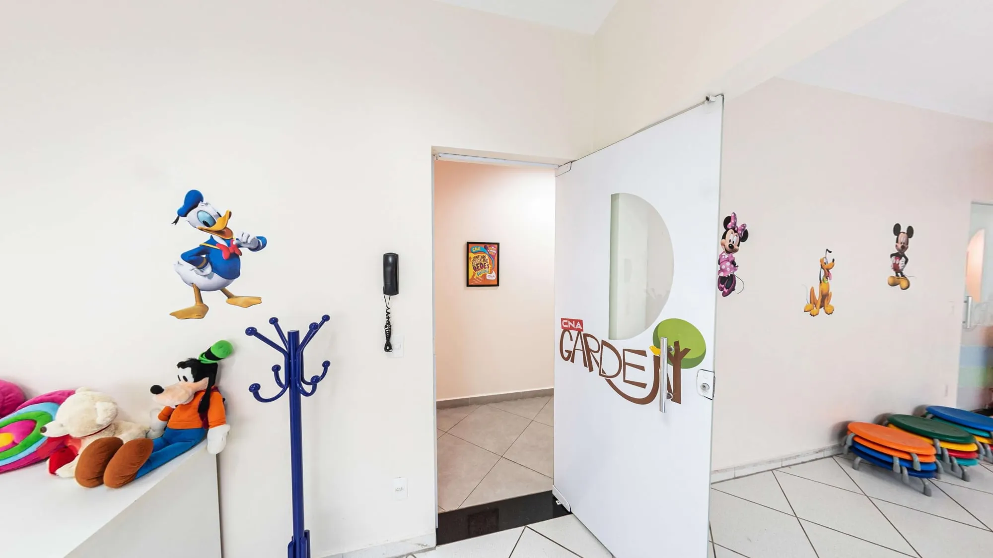 Sala Garden do CNA Itapetininga, com adesivos do Pato Donald, do Pateta e da Minnie, brinquedos e mesas infantis