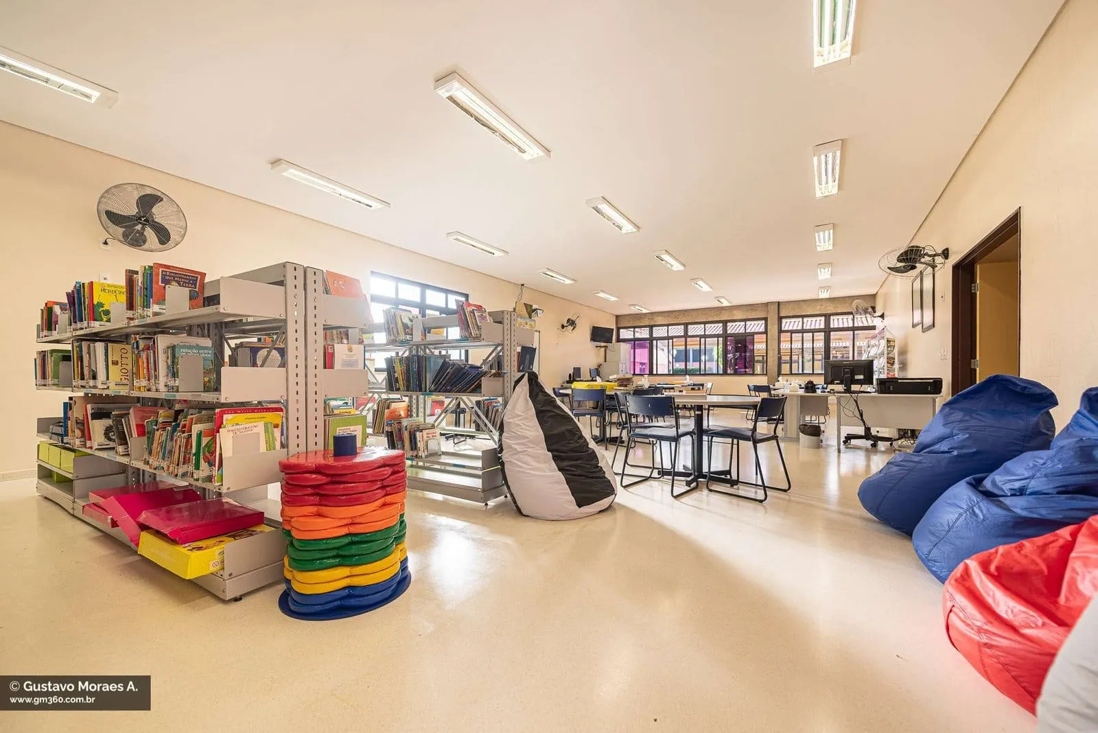 Biblioteca do SESI Itapetininga com estantes, mesas e pufes coloridos