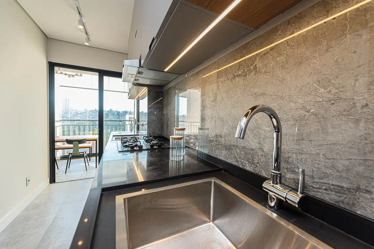Cozinha integrada com vista para a varanda do decorado Haus Residence Club