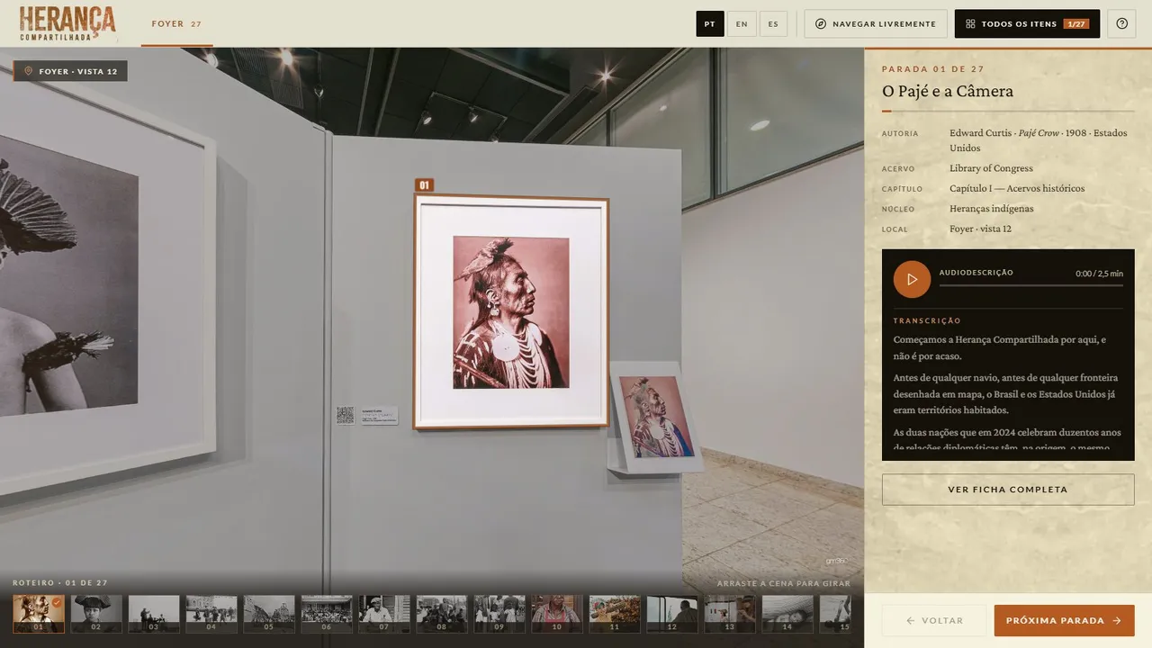 Visita guiada no tour da exposição Herança Compartilhada, na parada 1 de 27: a obra O Pajé e a Câmera destacada na cena, com a ficha, o player de audiodescrição e a transcrição no painel ao lado