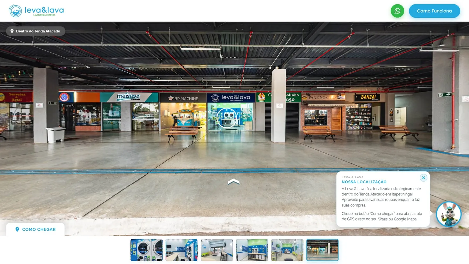 Galeria do Tenda Atacado no tour, com a fachada da Leva & Lava entre outras lojas e o balão Nossa Localização do coelho explicando que a lavanderia fica dentro do Tenda Atacado