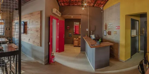 Interior da Mr Johnnie Hamburgueria com porta vermelha, balcão de atendimento e parede amarela