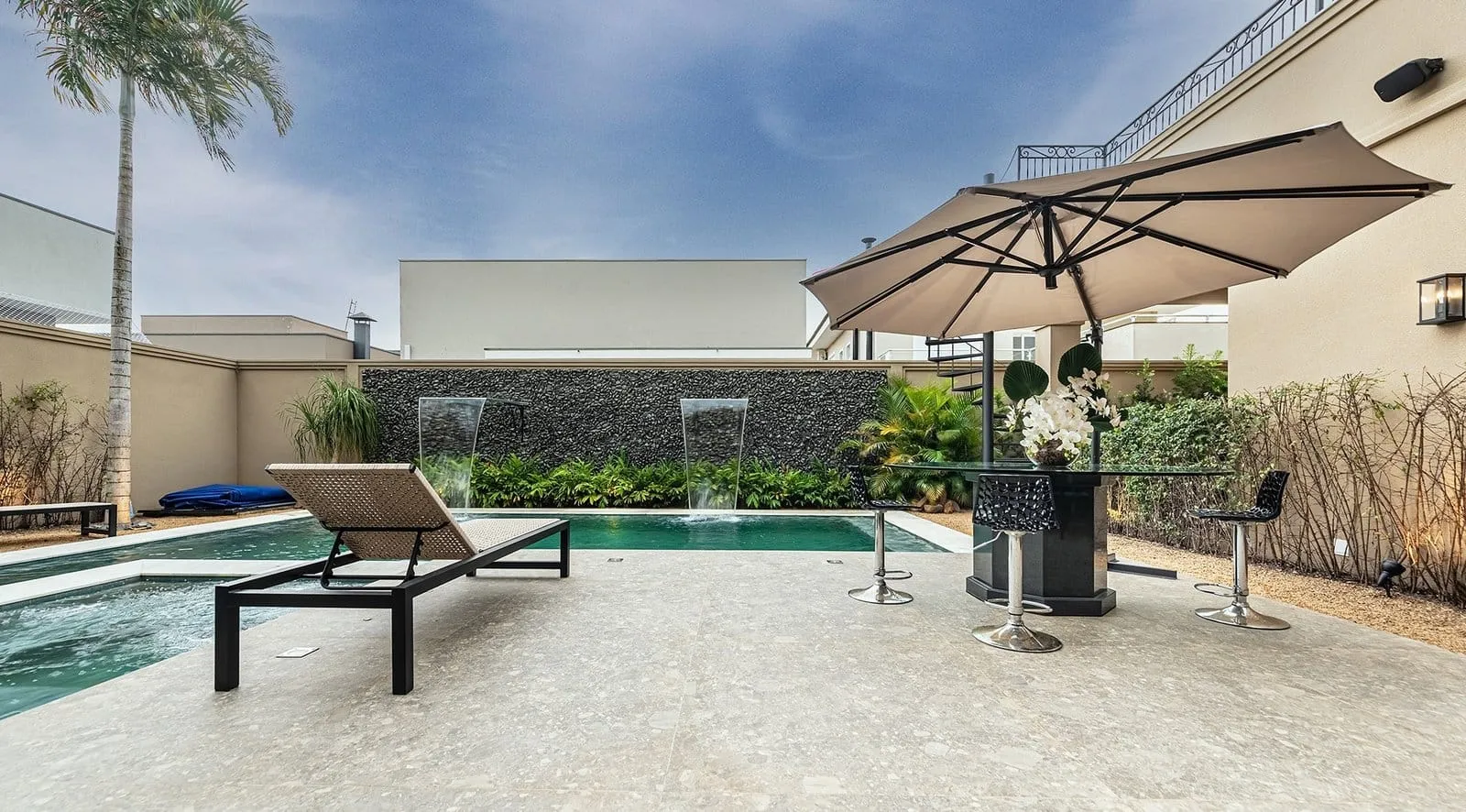 Deck da piscina da Residência R&M com espreguiçadeiras e ombrelones