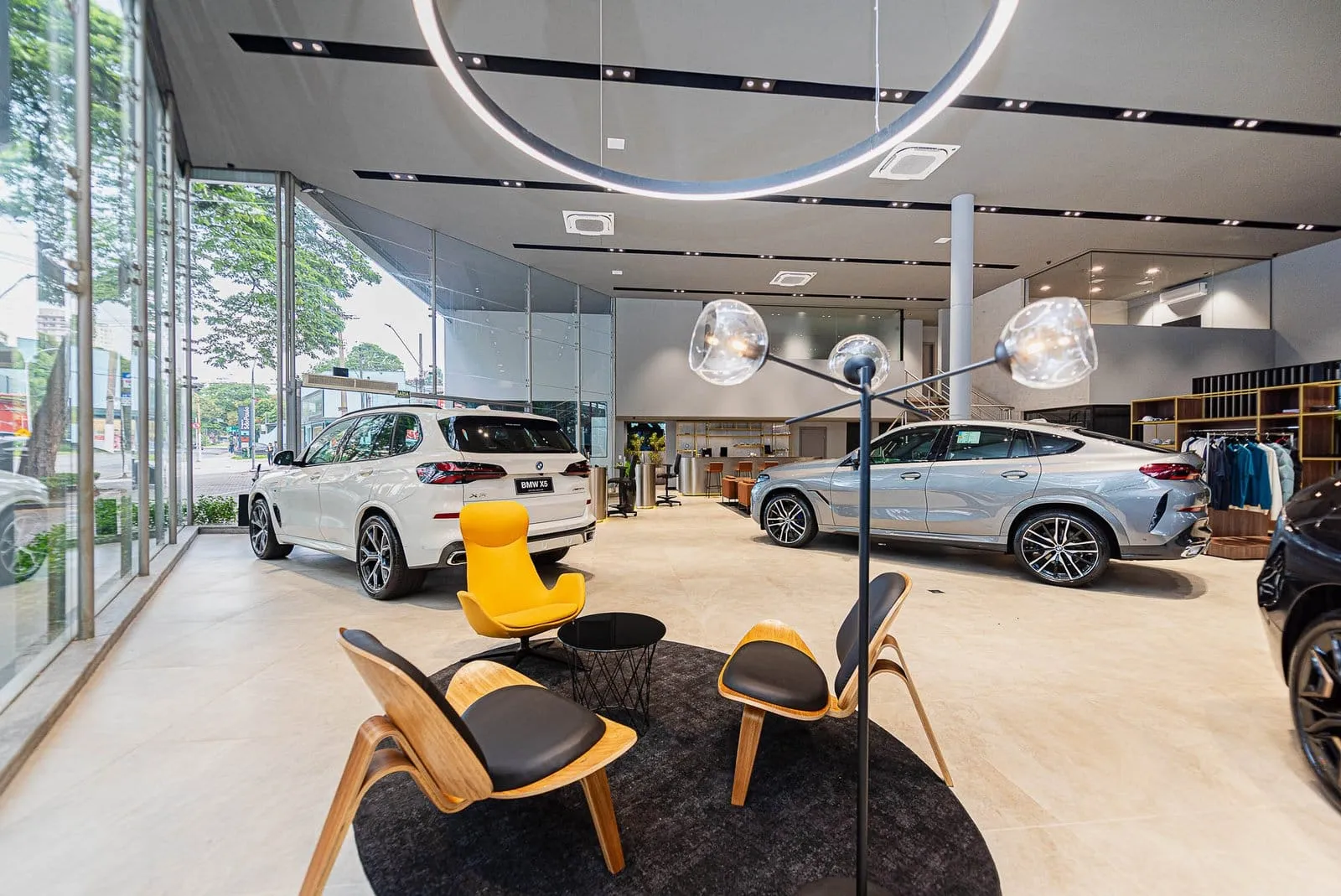 Salão da BMW Osten Perdizes com poltronas, tapete redondo e modelos BMW junto às vidraças